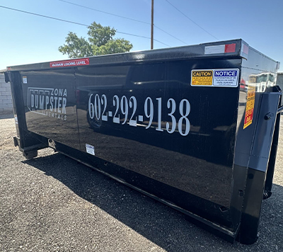 20 YARD DUMPS A black dumpster marked "Zona Dumpster Rentals" with contact number 602-292-9138, set against a clear blue sky.